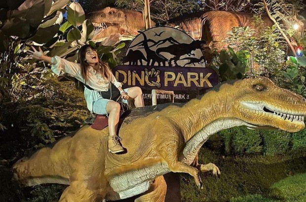 Perempuan menunggangi T-rex