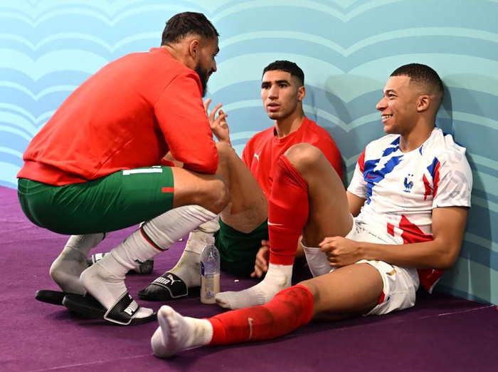 AL KHOR, QATAR - DECEMBER 14: Kylian Mbappe of France interacts with Sofiane Boufal (L) and Achraf Hakimi of Morocco in the tunnel after the FIFA World Cup Qatar 2022 semi final match between France and Morocco at Al Bayt Stadium on December 14, 2022 in Al Khor, Qatar. (Photo by Michael Regan - FIFA/FIFA via Getty Images)