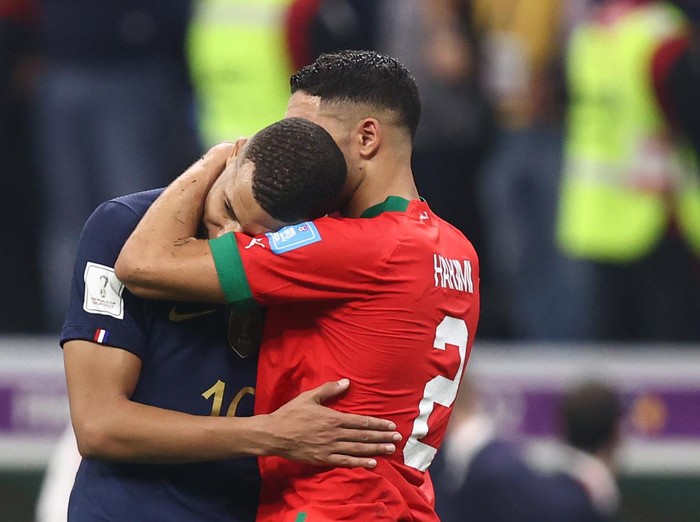 AL KHOR, QATAR - DECEMBER 14: Kylian Mbappe of France embraces fellow PSG team mate Achraf Hakimi of Morocco  during the FIFA World Cup Qatar 2022 semi final match between France and Morocco at Al Bayt Stadium on December 14, 2022 in Al Khor, Qatar. (Photo by James Williamson - AMA/Getty Images)