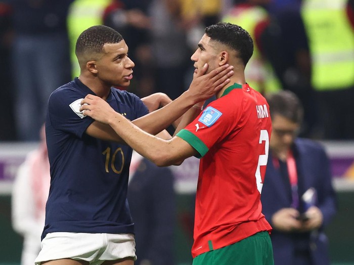AL KHOR, QATAR - DECEMBER 14: Kylian Mbappe of France embraces fellow PSG team mate Achraf Hakimi of Morocco  during the FIFA World Cup Qatar 2022 semi final match between France and Morocco at Al Bayt Stadium on December 14, 2022 in Al Khor, Qatar. (Photo by James Williamson - AMA/Getty Images)