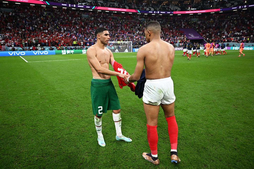 AL KHOR, QATAR - DECEMBER 14: Achraf Hakimi of Morocco exchanges shirts with Kylian Mbappe of France after the 2022 Qatar FIFA World Cup semi-final match between France and Morocco at Al Bayt Stadium on December 14, 2022 in Al Khor, Qatar.  (Photo by Michael Regan - FIFA/FIFA via Getty Images)