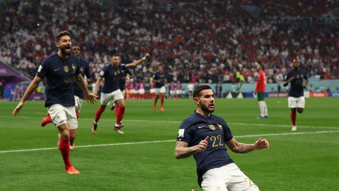 Frances defender #22 Theo Hernandez celebrates, with Frances forward #09 Olivier Giroud running behind, after scoring his teams first goal during the Qatar 2022 World Cup semi-final football match between France and Morocco at the Al-Bayt Stadium in Al Khor, north of Doha on December 14, 2022. (Photo by Adrian DENNIS / AFP) (Photo by ADRIAN DENNIS/AFP via Getty Images)