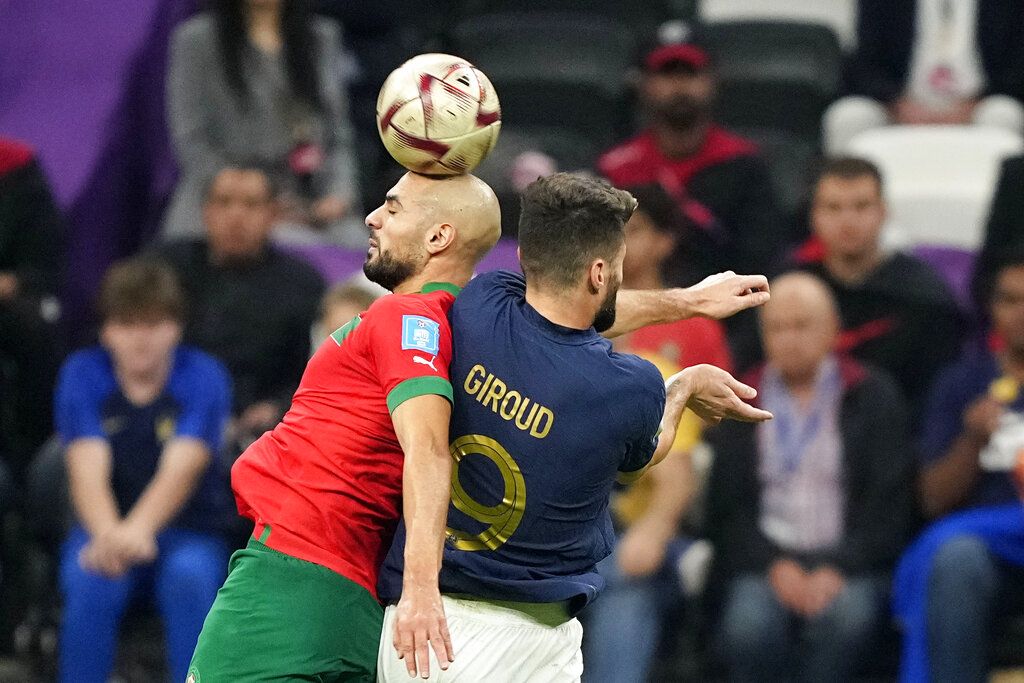 France's Olivier Giroud, right, and Morocco's Sofyan Amrabat challenge for the ball during the World Cup semifinal soccer match between France and Morocco at the Al Bayt Stadium in Al Khor, Qatar, Wednesday, Dec. 14, 2022. (AP Photo/Martin Meissner)