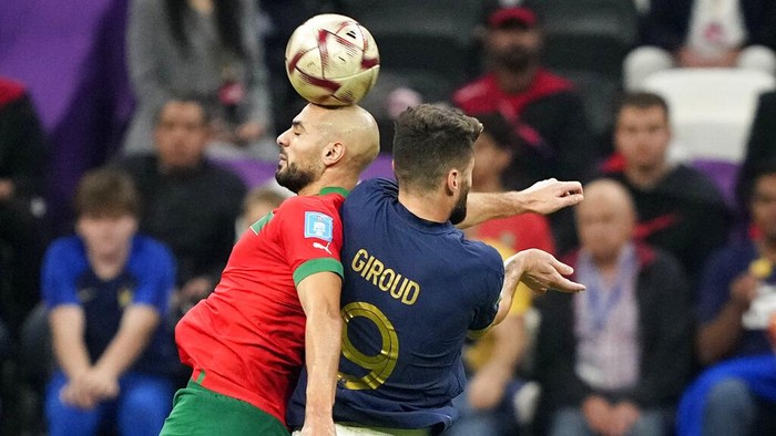 Frances Olivier Giroud, right, and Moroccos Sofyan Amrabat challenge for the ball during the World Cup semifinal soccer match between France and Morocco at the Al Bayt Stadium in Al Khor, Qatar, Wednesday, Dec. 14, 2022. (AP Photo/Martin Meissner)