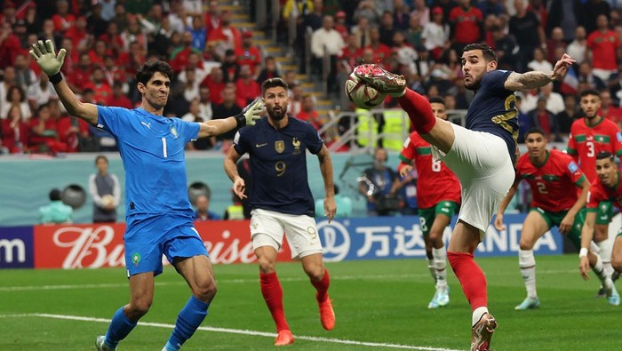 TOPSHOT - France's defender #22 Theo Hernandez strikes the ball to score his team's first goal past Morocco's goalkeeper #01 Yassine Bounou during the Qatar 2022 World Cup semi-final football match between France and Morocco at the Al-Bayt Stadium in Al Khor, north of Doha on December 14, 2022. (Photo by Adrian DENNIS / AFP) (Photo by ADRIAN DENNIS/AFP via Getty Images)