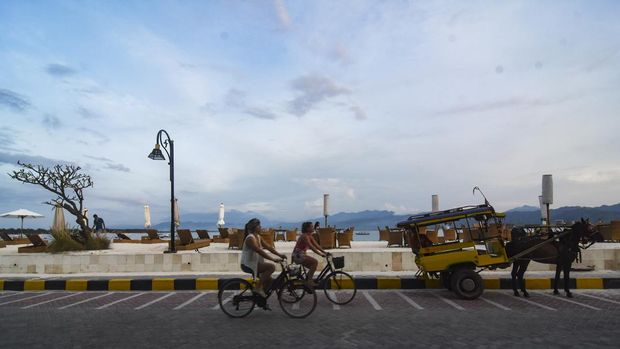WISATAWAN KUNJUNGI GILI TRAWANGAN JELANG AKHIR TAHUN Wisatawan asing menaiki sepeda di pinggiran pantai wisata Gili Trawangan, Kecamatan Pemenang, Tanjung, Lombok Utara, NTB, Rabu (14/12/2022). Menjelang libur Natal dan Tahun Baru 2023 wisatawan asing mulai ramai mengunjungi destinasi wisata Gili Trawangan.ANTARA FOTO/Ahmad Subaidi/aww.