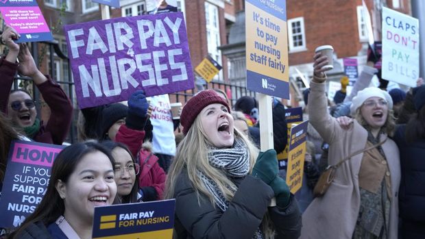 Nurses demonstrate towards passing traffic as they stand at a picket line outside the Royal Marsden Hospital in London, Thursday, Dec. 15, 2022, during what is expected to be a month of strikes by public service workers. (AP Photo/Kirsty Wigglesworth)