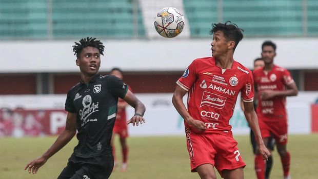 PERSIJA IMBANG MELAWAN PERSEBAYA Pesepak bola Persija Jakarta Dony Pamungkas (kanan) berebut bola dengan pesepak bola Persebaya Surabaya Alta Ballah (kiri) pada pertandingan Liga 1 di Stadion Maguwoharjo, Sleman, DI Yogyakarta, Jumat (16/12/2022). Pertandingan tersebut berakhir imbang dengan skor 1-1. ANTARA FOTO/Hendra Nurdiyansyah/foc.