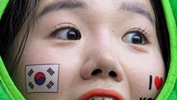 Seorang anak pendukung Timnas Korea Selatan memakai stiker bendera di wajahnya. (Salih Zeki Fazlioglu/Getty Images)