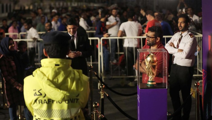 Warga Qatar Antre Panjang Demi Foto Bareng Trofi Piala Dunia 2022 DOHA, QATAR - DECEMBER 15: People take a photo with the FIFA World Cup trophy exhibited in the Corniche Street of Doha, Qatar on December 15, 2022. (Photo by Ashraf Amra/Anadolu Agency via Getty Images)