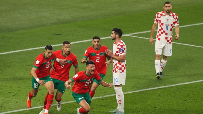Moroccos defender Achraf Dari (3L) celebrates with teammates after scoring his teams first goal during the Qatar 2022 World Cup football third place play-off match between Croatia and Morocco at Khalifa International Stadium in Doha on December 17, 2022. (Photo by ADRIAN DENNIS / AFP) (Photo by ADRIAN DENNIS/AFP via Getty Images)