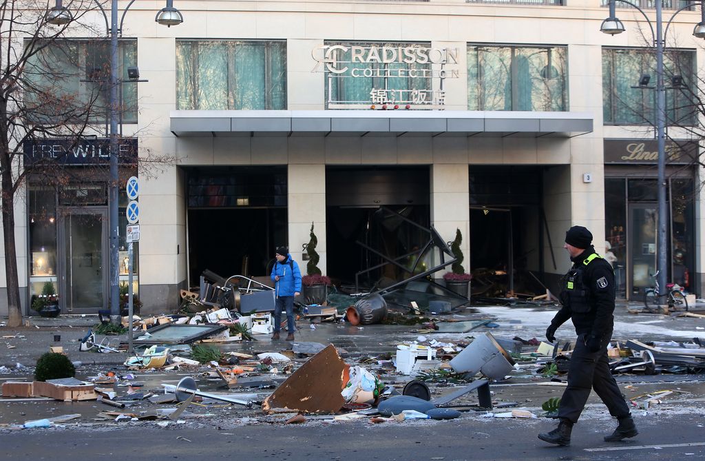 BERLIN, GERMANY - DECEMBER 16: Emergency workers respond at the scene of a broken giant aquarium, on December 16, 2022 in Berlin, Germany. The aquarium, located in the Radisson Hotel in the Domaquarée complex, spilled approximately 1,500 exotic fish and pushed debris from the hotel’s lobby out onto a heavy pedestrian and traffic thoroughfare when it burst in the early morning. The owners claim the aquarium, which houses the hotel’s central guest elevator and flooded the hotel with one million liters (264,172 gallons) when it broke, is the world's largest freestanding cylindrical one at 14 meters (46 feet) in height. (Photo by Adam Berry/Getty Images)