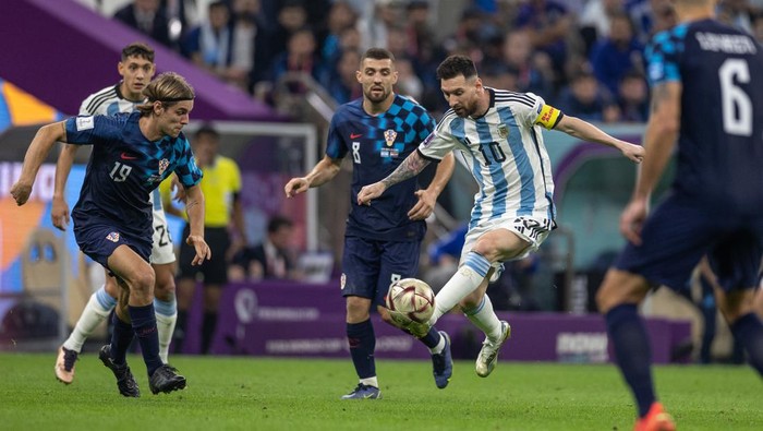 LUSAIL CITY, QATAR - DECEMBER 13: Lionel Messi of Argentina in action while under pressure from Borna Sosa of Croatia and Mateo Kovacic of Croatia during the FIFA World Cup Qatar 2022 semi final match between Argentina (3) and Croatia (0) at Lusail Stadium on December 13, 2022 in Lusail City, Qatar. (Photo by Simon Bruty/Anychance/Getty Images)