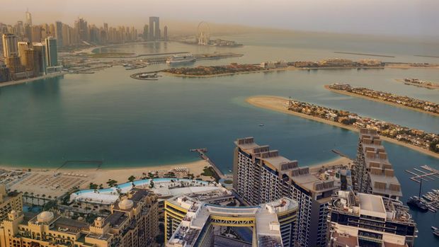 Matahari terbit di atas kota di The Palm Jumeirah di Dubai, Uni Emirat Arab, Minggu (10/4/2022). (Photo by Laszlo Szirtesi/Getty Images)