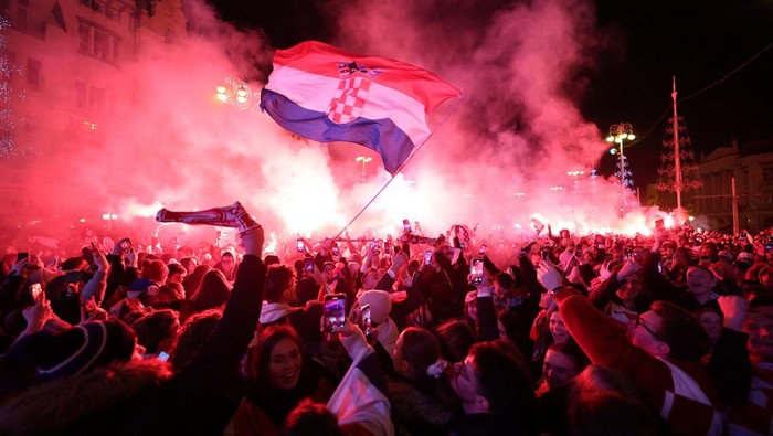 Euforia Fans Kroasia Usai Finis Ketiga Piala Dunia 2022 Soccer Football - FIFA World Cup Qatar 2022 - Fans in Zagreb watch Croatia v Morocco - Zagreb, Croatia - December 17, 2022 Croatia fan with flares in Ban Josip Jelacic Square celebrate after the match as they finish in third place REUTERS/Antonio Bronic TPX IMAGES OF THE DAY