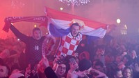 Fan yang gembira mengibarkan bendera Kroasia saat merayakan kemenangan timnas Krosia dan finis ketiga di Piala Dunia 2022. 