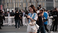 Seorang wanita pendukung Argentina sedang menunggu kawannya di area pintu masuk.