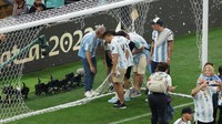 Argentina meluapkan rasa suka citanya dengan berbeda-beda seusai dinobatkan jadi juara Piala Dunia 2022. Salah satunya adalah dengan merobek jala gawang yang dipakai saat laga final. Getty Images/Richard Heathcote  