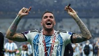 Rodrigo De Paul dari Argentina merayakan dengan medalinya dan bagian dari jaring gawang setelah memenangkan Piala Dunia. Reuters/Lee Smith  