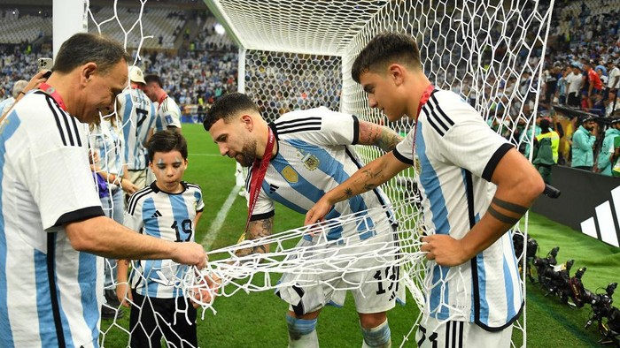 LUSAIL CITY, QATAR - DECEMBER 18: Nicolas Otamendi and Paulo Dybala of Argentina cut a piece of the net from the goal after winning the FIFA World Cup after the FIFA World Cup Qatar 2022 Final match between Argentina and France at Lusail Stadium on December 18, 2022 in Lusail City, Qatar. (Photo by David Ramos - FIFA/FIFA via Getty Images)