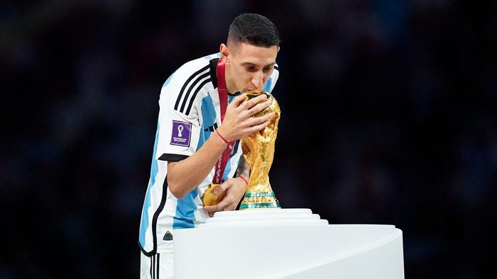 LUSAIL CITY, QATAR - DECEMBER 18: Angel Di Maria of Argentina kisses the FIFA World Cup Winners Trophy at the award ceremony following the FIFA World Cup Qatar 2022 Final match between Argentina and France at Lusail Stadium on December 18, 2022 in Lusail City, Qatar. (Photo by Quality Sport Images/Getty Images)