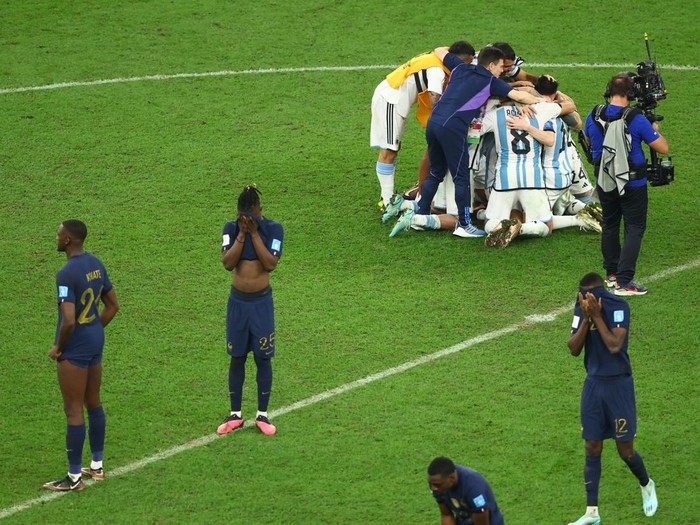 Soccer Football - FIFA World Cup Qatar 2022 - Final - Argentina v France - Lusail Stadium, Lusail, Qatar - December 18, 2022 Argentina players celebrate after winning the World Cup as France players looks dejected after the match REUTERS/Bernadett Szabo