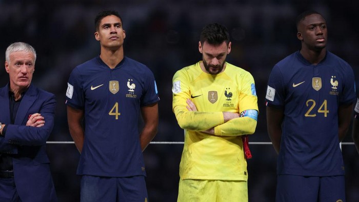 LUSAIL CITY, QATAR - DECEMBER 18: (L - R) Didier Deschamps, Head Coach of France, Raphael Varane, Hugo Lloris and Ibrahima Konate of France look dejected as they stand on the podium following defeat during the FIFA World Cup Qatar 2022 Final match between Argentina and France at Lusail Stadium on December 18, 2022 in Lusail City, Qatar. (Photo by Julian Finney/Getty Images)
