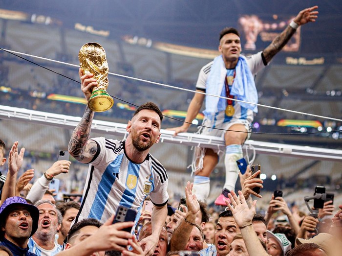 LUSAIL CITY, QATAR - DECEMBER 18: Lionel Messi of Argentina lifts the Fifa World Cup Trophy with Lautaro Martinez after winning the FIFA World Cup Qatar 2022 Final match between Argentina and France at Lusail Stadium on December 18, 2022 in Lusail City, Qatar. (Photo by MB Media/Getty Images)