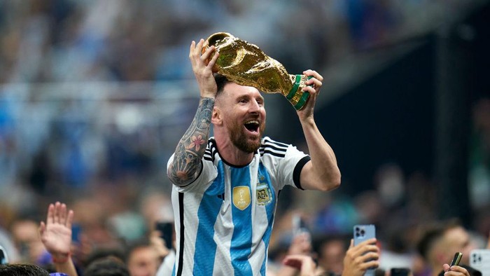 LUSAIL CITY, QATAR - DECEMBER 18: Lionel Messi of Argentina celebrates with the World Cup trophy after the FIFA World Cup Qatar 2022 Final match between Argentina and France at Lusail Stadium on December 18, 2022 in Lusail City, Qatar. (Photo by Quality Sport Images/Getty Images)