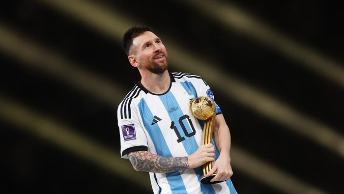 Soccer Football - FIFA World Cup Qatar 2022 - Final - Argentina v France - Lusail Stadium, Lusail, Qatar - December 18, 2022 Argentinas Lionel Messi celebrates winning the Golden Ball award with the trophy REUTERS/Carl Recine