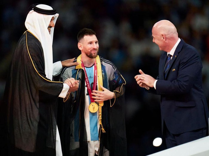 LUSAIL CITY, QATAR - DECEMBER 18: Lionel Messi of Argentina receives a Robe from Tamim bin Hamad Al Thani the Emir of Qatar  during the FIFA World Cup Qatar 2022 Final match between Argentina and France at Lusail Stadium on December 18, 2022 in Lusail City, Qatar. (Photo by Quality Sport Images/Getty Images)