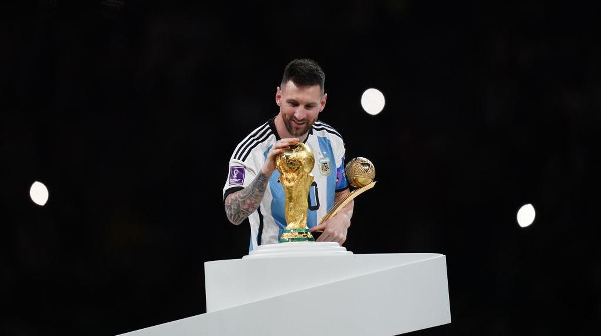 Lionel Messi mengelus trofi Piala Dunia. Foto: Getty Images/Jam Media