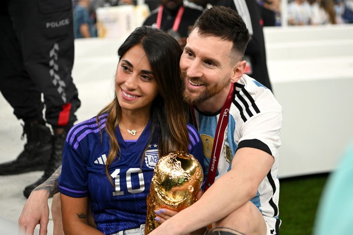 LUSAIL CITY, QATAR - DECEMBER 18: Lionel Messi of Argentina celebrates with his wife Antonela Roccuzzo and the FIFA World Cup Qatar 2022 Winners Trophy following the FIFA World Cup Qatar 2022 Final match between Argentina and France at Lusail Stadium on December 18, 2022 in Lusail City, Qatar. (Photo by Shaun Botterill - FIFA/FIFA via Getty Images)