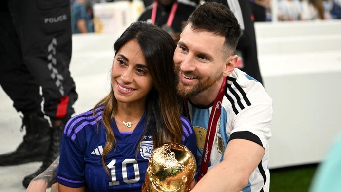 LUSAIL CITY, QATAR - DECEMBER 18: Lionel Messi of Argentina celebrates with his wife Antonela Roccuzzo and the FIFA World Cup Qatar 2022 Winners Trophy following the FIFA World Cup Qatar 2022 Final match between Argentina and France at Lusail Stadium on December 18, 2022 in Lusail City, Qatar. (Photo by Shaun Botterill - FIFA/FIFA via Getty Images)