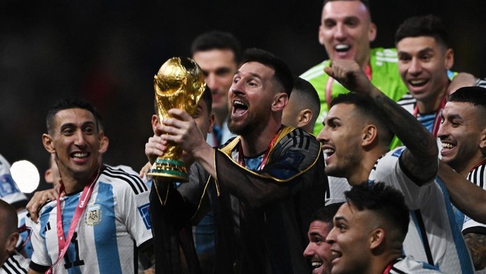 Soccer Football - FIFA World Cup Qatar 2022 - Final - Argentina v France - Lusail Stadium, Lusail, Qatar - December 18, 2022   Argentinas Lionel Messi lifts the World Cup trophy alongside teammates as they celebrate after winning the World Cup REUTERS/Dylan Martinez