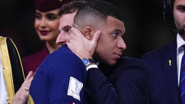 Frances Kylian Mbappe is consoled by French President Emmanuel Macron, at the end of the World Cup final soccer match between Argentina and France at the Lusail Stadium in Lusail, Qatar, Sunday, Dec.18, 2022. (AP Photo/Manu Fernandez)