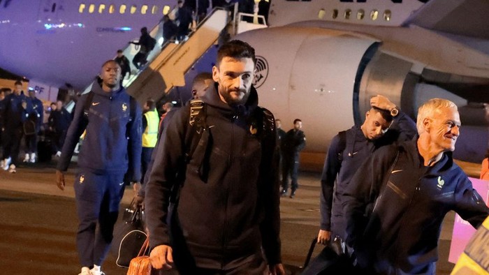 1245732904 France's goalkeeper Hugo Lloris (C), France's forward Kylian Mbappe (2ndR) and France's coach Didier Deschamps (R) walk on the tarmac during the return of the French national team from Qatar after losing the 2022 World Cup final football match against Argentina, at Roissy-Charles-de-Gaulle airport outside Paris, on December 19, 2022. (Photo by CHARLY TRIBALLEAU / AFP) (Photo by CHARLY TRIBALLEAU/AFP via Getty Images)