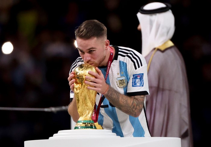 LUSAIL CITY, QATAR - DECEMBER 18: Alexis Mac Allister of Argentina kissing the World Cup during the trophy ceremony following the FIFA World Cup Qatar 2022 Final match between Argentina and France at Lusail Stadium on December 18, 2022 in Lusail City, Qatar. (Photo by Jean Catuffe/Getty Images)