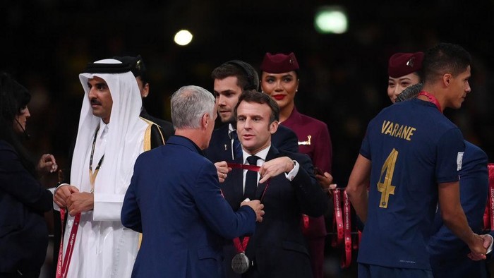 LUSAIL CITY, QATAR - DECEMBER 18: Didier Deschamps, Head Coach of France, is embraced by French President Emmanuel Macron at the award ceremony following the FIFA World Cup Qatar 2022 Final match between Argentina and France at Lusail Stadium on December 18, 2022 in Lusail City, Qatar. (Photo by Shaun Botterill - FIFA/FIFA via Getty Images)