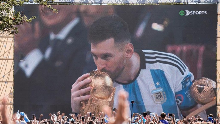 BUENOS AIRES, ARGENTINA - DECEMBER 18: Leo Messi is seen on the screen installed in the Intendente Seeber Park in Buenos Aires, Argentina on December 18, 2022. Fans from Argentina celebrate the victory of Argentina during live the Qatar 2022 FIFA World Cup final match. (Photo by Diego Radames/Anadolu Agency via Getty Images)