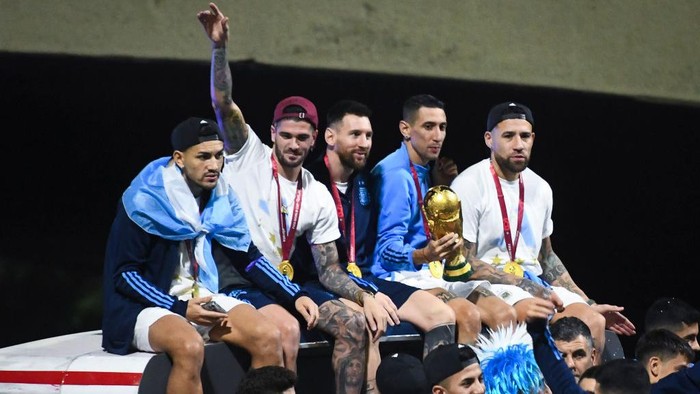 BUENOS AIRES, ARGENTINA - DECEMBER 20:  (L-R) Leandro Paredes, Rodrigo De Paul, Lionel Messi, Angel Di Maria and Nicolas Otamendi celebrate on the bus during the arrival of the Argentina mens national football team after winning the FIFA World Cup Qatar 2022 on December 20, 2022 in Buenos Aires, Argentina. (Photo by Rodrigo Valle/Getty Images)