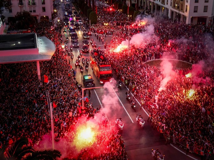 Supporters light flares and cheer as Morocco's national football team arrives to the center of the capital Rabat, on December 20, 2022, after the Qatar 2022 World Cup. (Photo by FADEL SENNA / AFP) (Photo by FADEL SENNA/AFP via Getty Images)