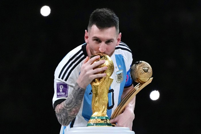 LUSAIL CITY, QATAR - DECEMBER 18: Adidas Golden Ball winner Lionel Messi of Argentina kisses the FIFA World Cup Winners Trophy at the award ceremony following the FIFA World Cup Qatar 2022 Final match between Argentina and France at Lusail Stadium on December 18, 2022 in Lusail City, Qatar. (Photo by Cui Nan/China News Service/VCG via Getty Images)