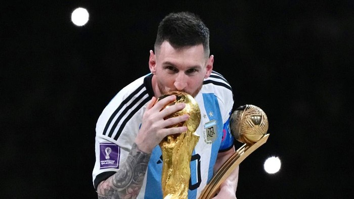 LUSAIL CITY, QATAR - DECEMBER 18: Adidas Golden Ball winner Lionel Messi of Argentina kisses the FIFA World Cup Winners Trophy at the award ceremony following the FIFA World Cup Qatar 2022 Final match between Argentina and France at Lusail Stadium on December 18, 2022 in Lusail City, Qatar. (Photo by Cui Nan/China News Service/VCG via Getty Images)