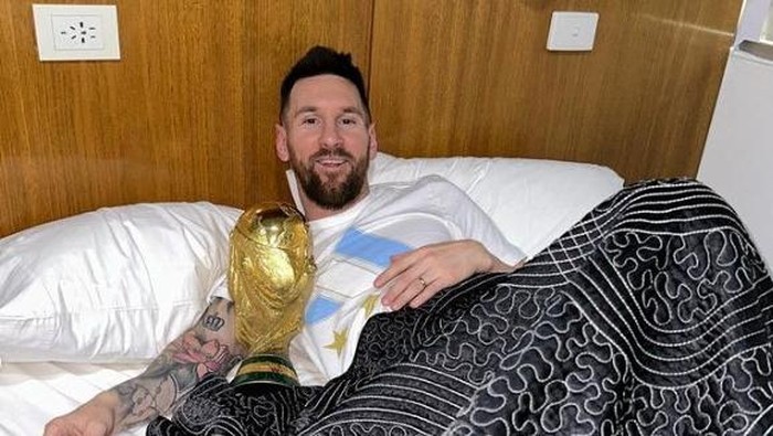 Argentina's Lionel Messi lies in bed with the FIFA World Cup trophy, at an unknown location, in this screenshot taken from social media and released on December 20, 2022. Instagram/leomessi/via REUTERS THIS IMAGE HAS BEEN SUPPLIED BY A THIRD PARTY. MANDATORY CREDIT. NO RESALES. NO ARCHIVES.