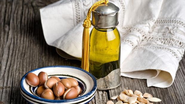 Bottle of argan oil and argan fruit. Argan oil is used for skincare products.