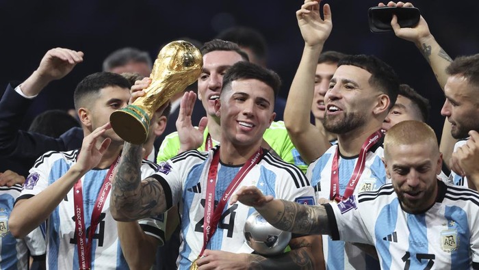 LUSAIL CITY, QATAR - DECEMBER 18: Enzo Fernandez of Argentina - holding the World Cup - and teammates celebrate during the trophy ceremony following the FIFA World Cup Qatar 2022 Final match between Argentina and France at Lusail Stadium on December 18, 2022 in Lusail City, Qatar. (Photo by Jean Catuffe/Getty Images)