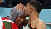 Achraf Hakimi disambut oleh ibunya pada akhir pertandingan sepak bola Grup F Piala Dunia 2022 Qatar antara Belgia dan Maroko di Stadion Al-Thumama di Doha. (Fedel Senna/AFP/Getty Images)  