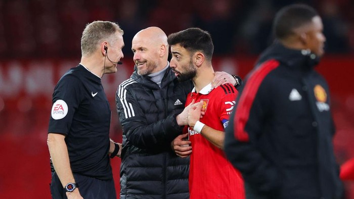 MANCHESTER, ENGLAND - DECEMBER 21: Bruno Fernandes of Manchester United is embraced by Erik ten Hag, manager of Manchester United, while arguing with referee Graham Scott after the Carabao Cup Fourth Round match between Manchester United and Burnley at Old Trafford on December 21, 2022 in Manchester, England. (Photo by James Gill - Danehouse/Getty Images)