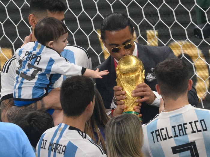 Nusret GΓΆkΓ§e 18 December 2022, Qatar, Lusail: Soccer, World Cup, Argentina - France, final round, final, Lusail Stadium, Turkish restaurateur Nusret GΓΆkΓ§e, alias Salt Bae, kisses the World Cup trophy. Photo: Robert Michael/dpa - IMPORTANT NOTE: In accordance with the requirements of the DFL Deutsche FuΓball Liga and the DFB Deutscher FuΓball-Bund, it is prohibited to use or have used photographs taken in the stadium and/or of the match in the form of sequence pictures and/or video-like photo series. (Photo by Robert Michael/picture alliance via Getty Images)